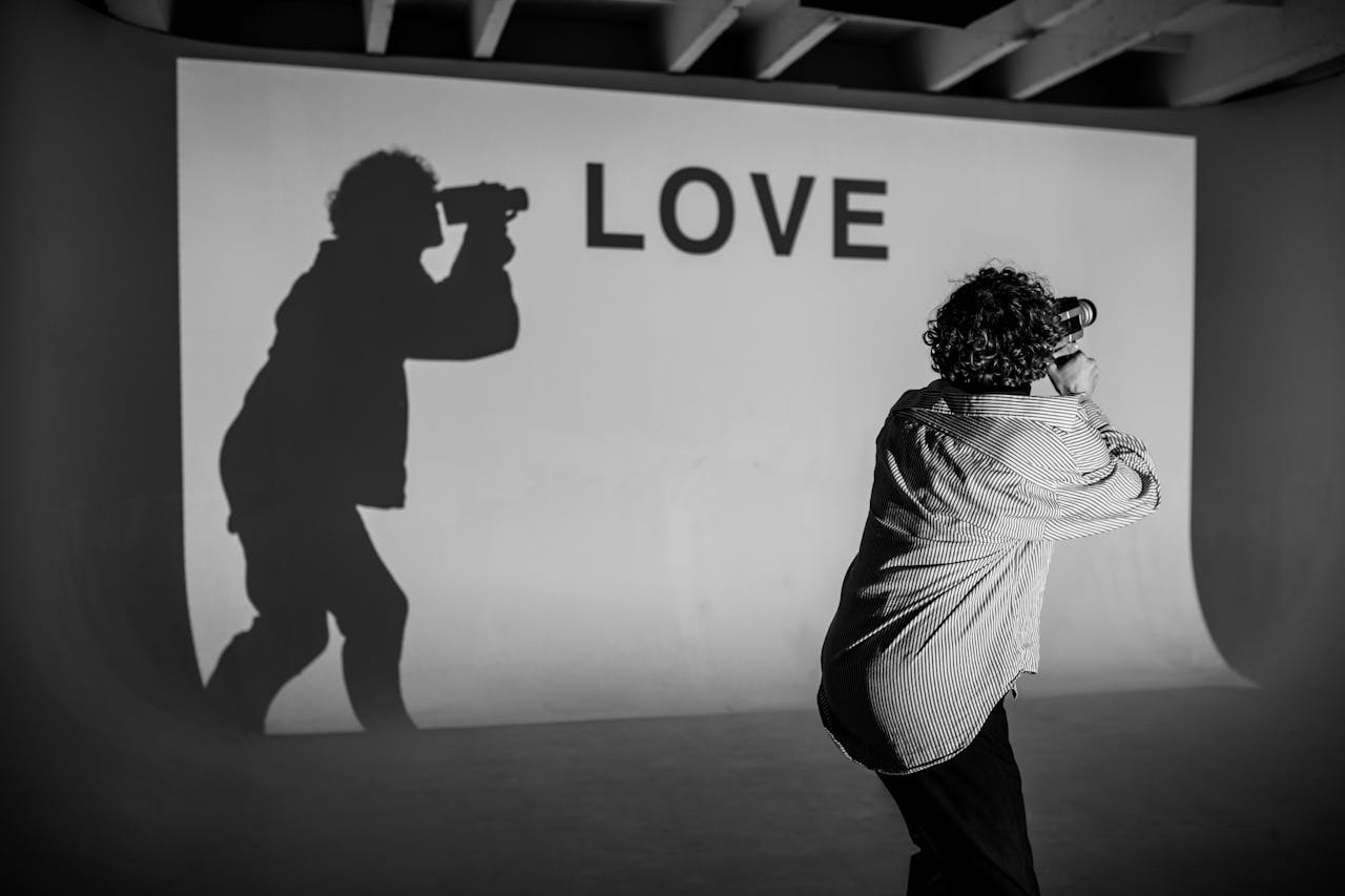 Creative monochrome photograph capturing a shadow and Love projection in a studio.